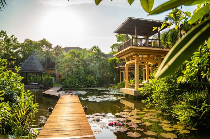 Steg der durch einen Teich mit Seerosen in einer Hotelanlage führt