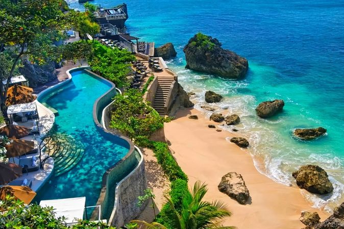 Infinity-Pool auf einer Terrasse oberhalb des Strandes. Unterhalb führt eine Treppe direkt zum Meer