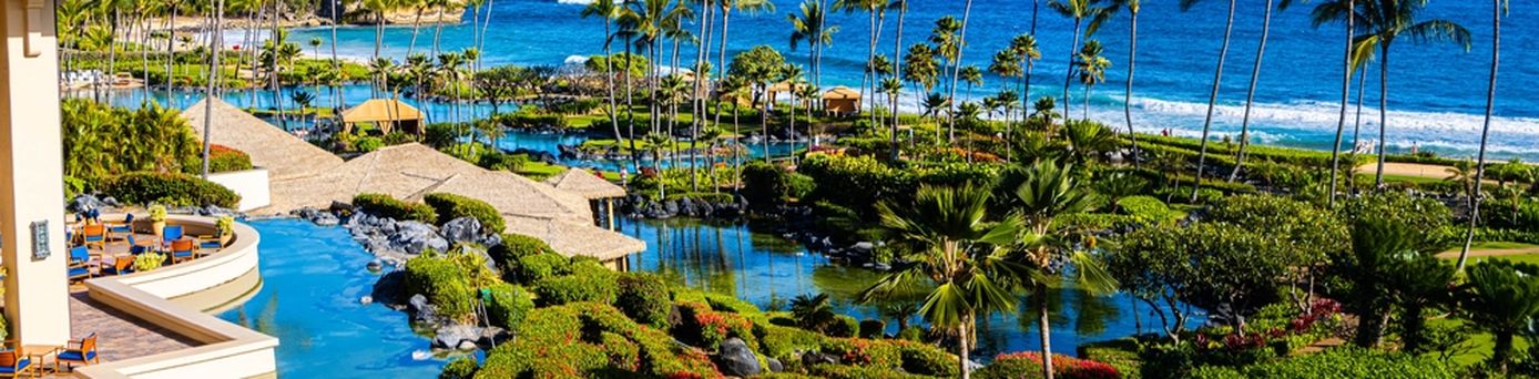 Ein Hotel mit mehreren Pool, Palmen und Strandzugang