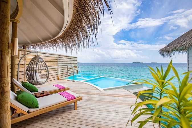 Eine Terrasse mit Privatpool und gemütlichen Liegen über dem Meer