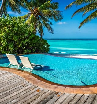 Ein kleiner Pool mit direktem Strandzugang und zwei Liegen