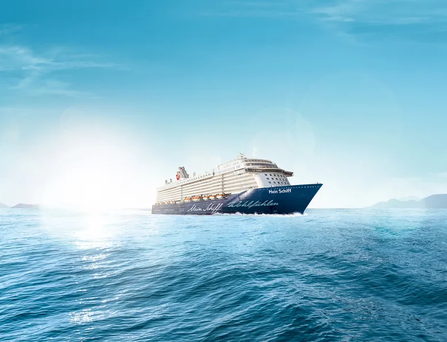 Ein Kreuzfahrtschiff fährt auf einem ruhigen Meer bei Sonnenschein