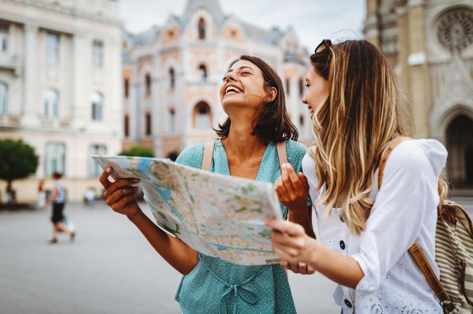 Zwei lachende Frauen mit einem Stadtplan
