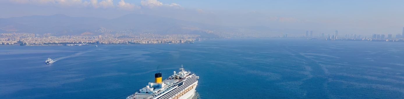 Weißes Kreuzfahrtschiff fährt bei sonnigem Wetter über das Meer