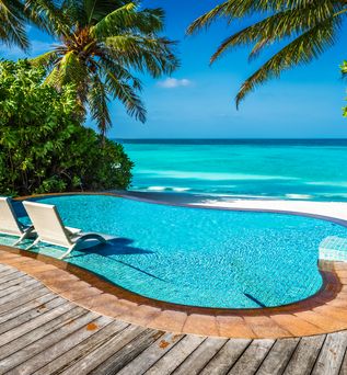 Ein kleiner Pool mit direktem Strandzugang und zwei Liegen