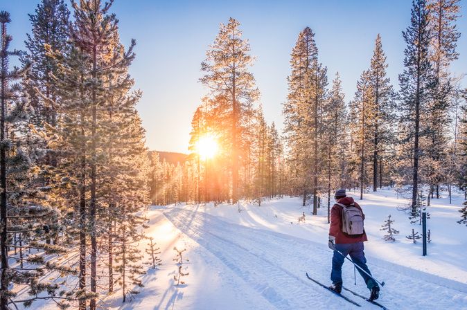 Mann auf Skiern läuft durch eine Schneelandschaft