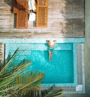 Eine Frau lehnt am Rand eines eleganten Pools