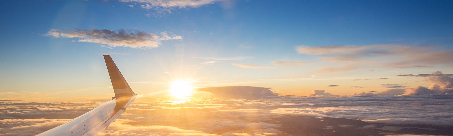 Sonnenuntergang über den Wolken aus einem Flugzeugfenster aus