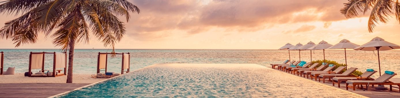 Ein Pool mit Meerblick bei Sonnenuntergang