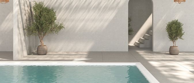 Ecke eines Pools. Im Hintergrund stehen zwei Topfpflanzen und ein Treppenaufgang ist zu sehen