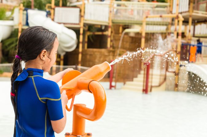 Kind spielt mit einer Wasserpistole in einem Aquapark