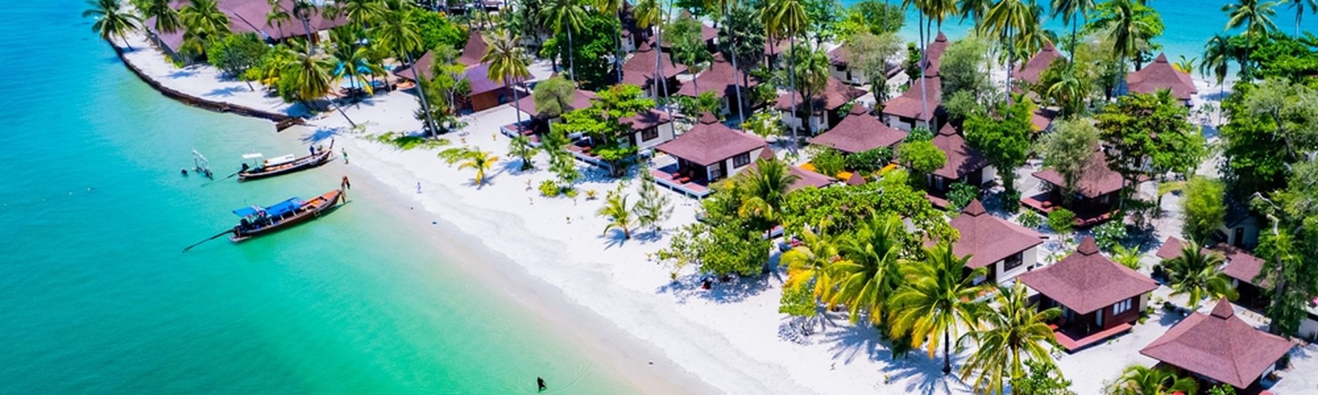 Teil einer Insel mit kleinen Häusern und Palmenstrand
