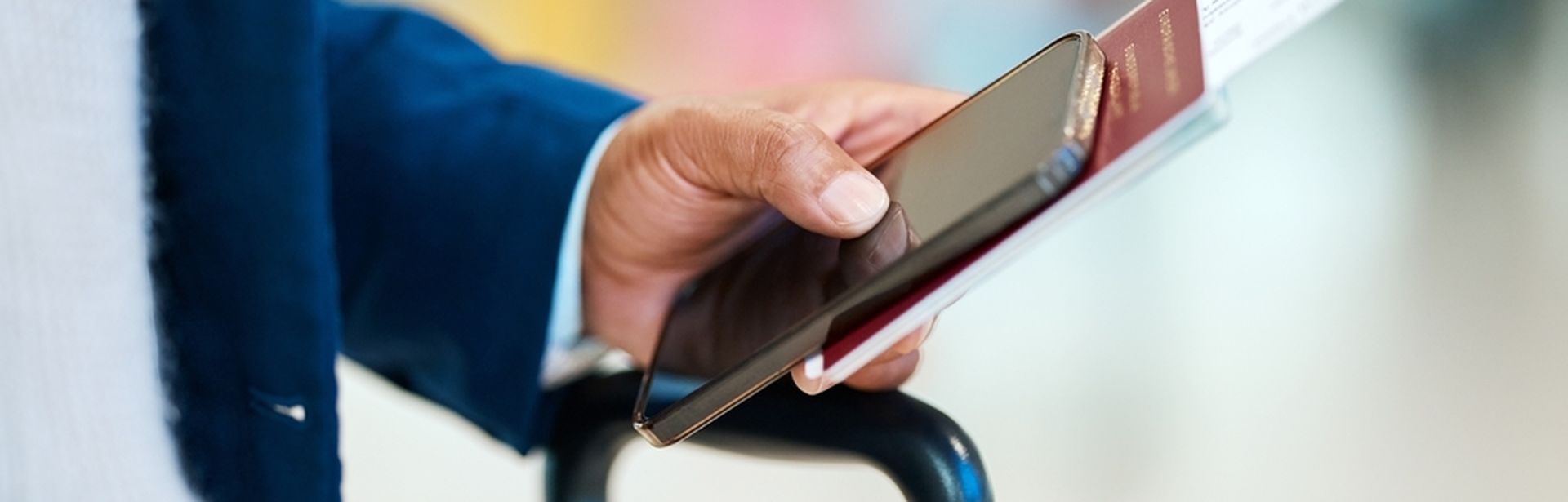 Eine Person hält einen Reisepass und Flugtickets in der Hand