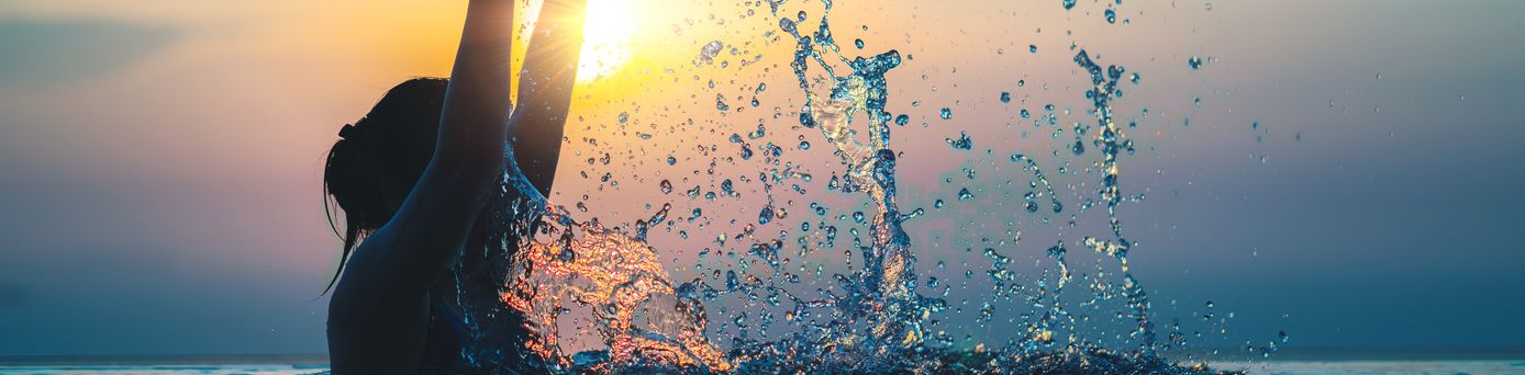 Frau im Pool bei Sonnenuntergang 