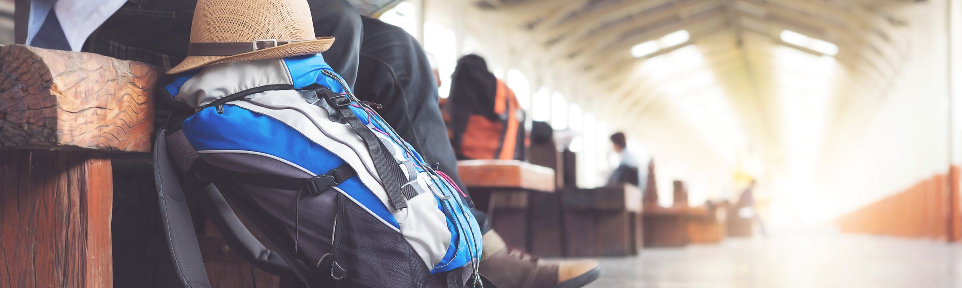 Rucksack und Hut liegen am Bahnhof, Mann mit Stadtplan