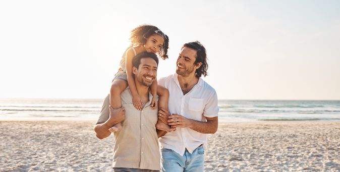 Eine Familie am Strand, Tochter sitzt auf den Schultern des Vaters