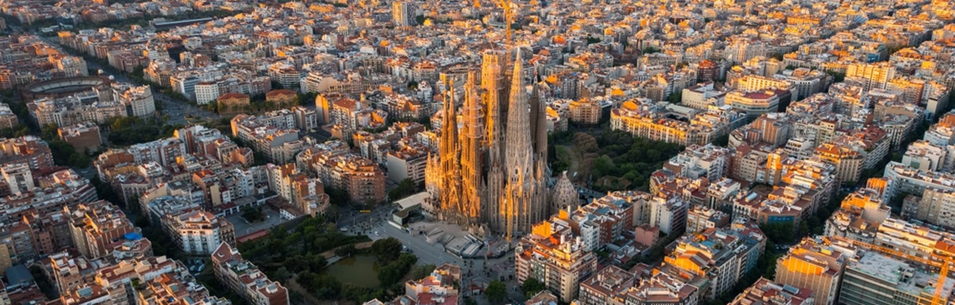 Barcelona von oben bei Sonnenuntergang, im Hintergrund das Meer