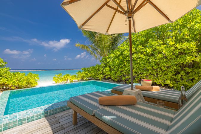 Private Pool mit zwei Liegen und einem Sonnenschirm
