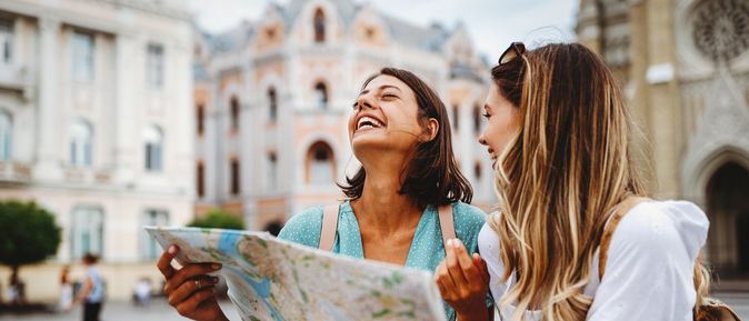 Zwei lachende Frauen mit einem Stadtplan