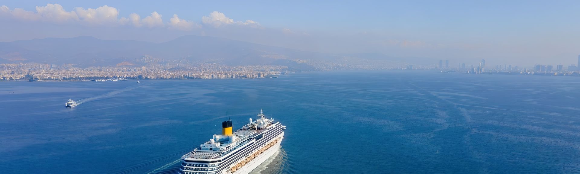 Weißes Kreuzfahrtschiff fährt bei Sonnigem Wetter über das Meer