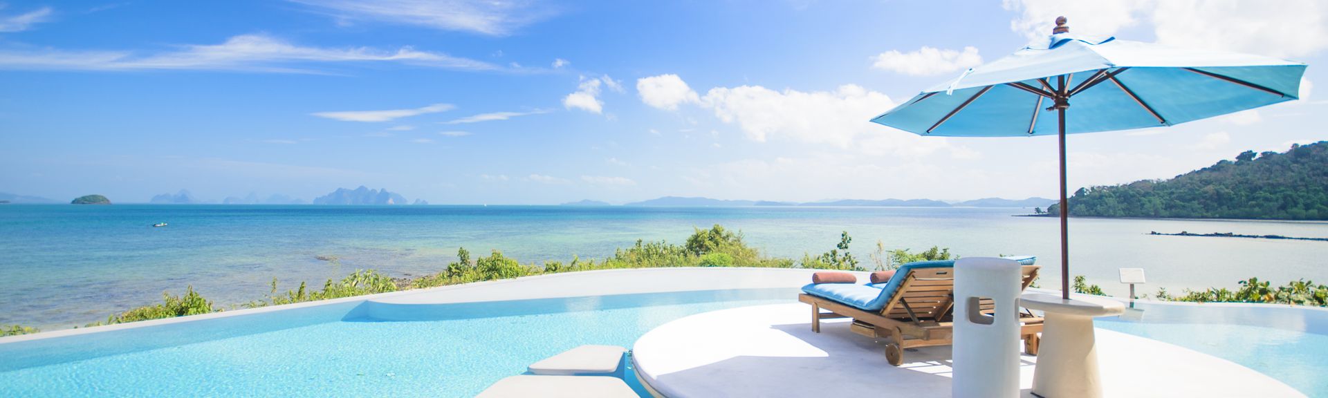 Ein Tisch mit kleinem Sonnenschirm und Getränken steht im Pool