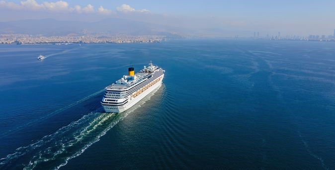 Weißes Kreuzfahrtschiff fährt bei Sonnigem Wetter über das Meer