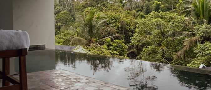 Blick auf einen Swim-up Pool mit Palmen im Hintergrund