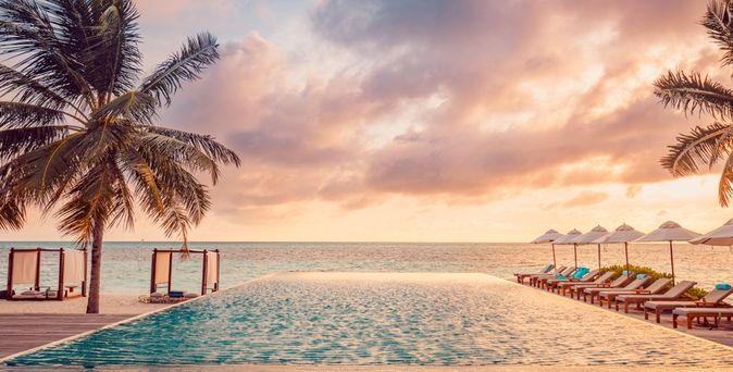 Ein Pool mit Meerblick bei Sonnenuntergang