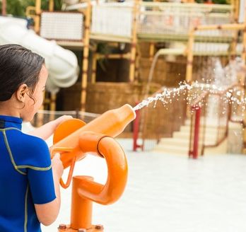 Kind spielt mit einer Wasserpistole in einem Aquapark