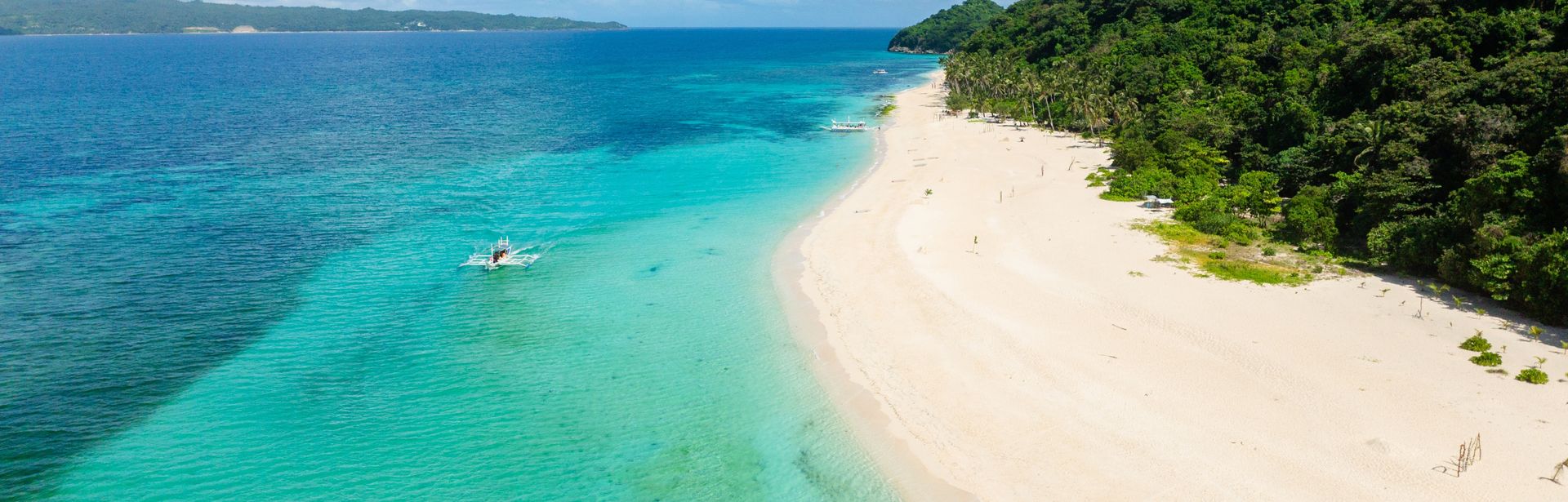 Sandstrand einer Insel mit einem Wald