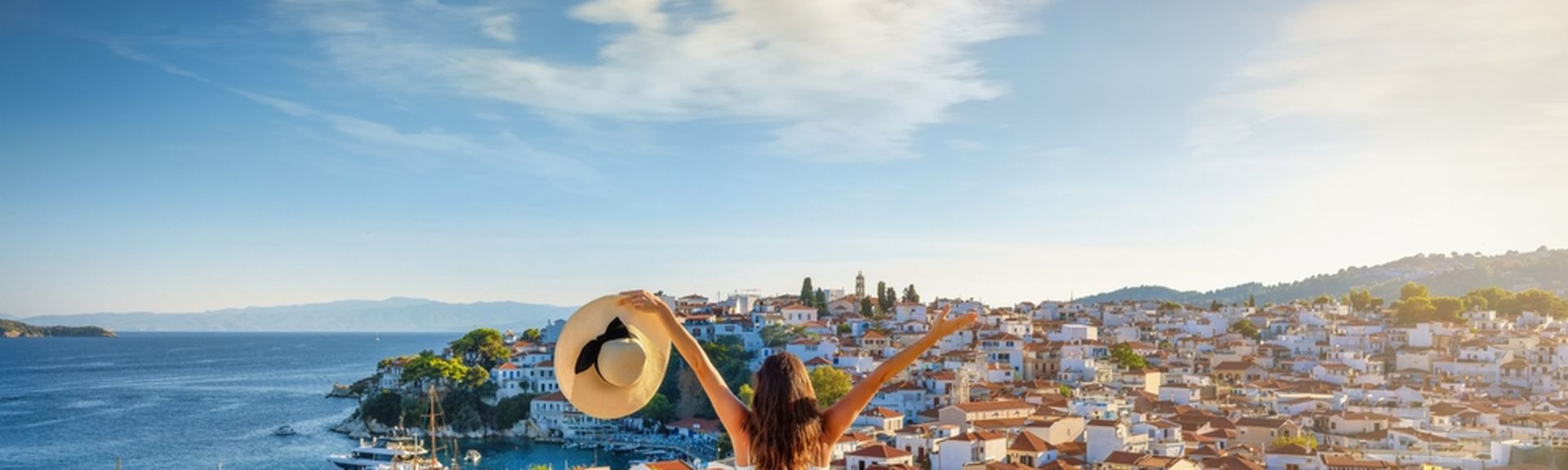 Eine glückliche Touristin genießt den schönen Sonnenuntergang im Sommer mit Blick auf die Stadt 