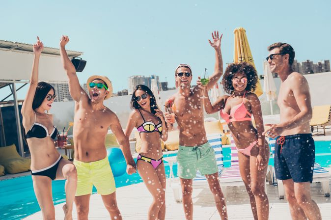 Gruppe von jungen Menschen feiert am Pool