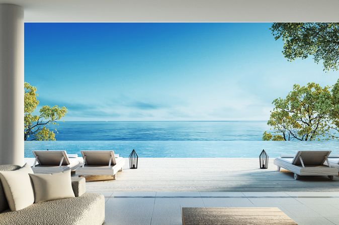 Moderne Terrasse mit Liegen und direktem Strandzugang