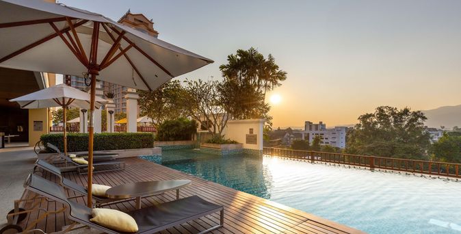 Pool mit zwei Liegen bei Sonnenuntergang