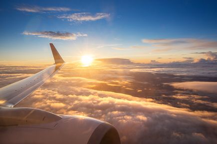 Sonnenuntergang über den Wolken aus einem Flugzeugfenster aus