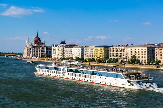 Kreuzfahrtschiff auf einem Fluss, der durch eine Stadt führt