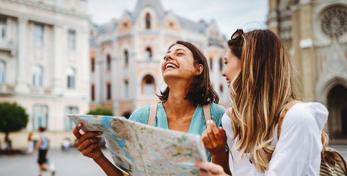 Zwei lachende Frauen mit einem Stadtplan