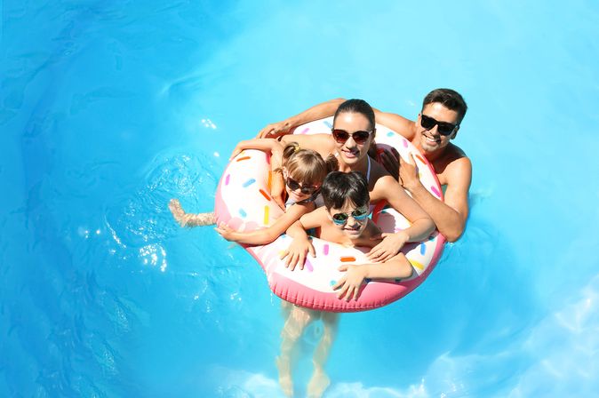 Eine Familie mit zwei Kindern und ein Schwimmreifen in einem Pool