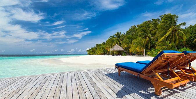 Zwei Liegen auf einer Terrasse mit Strandzugang
