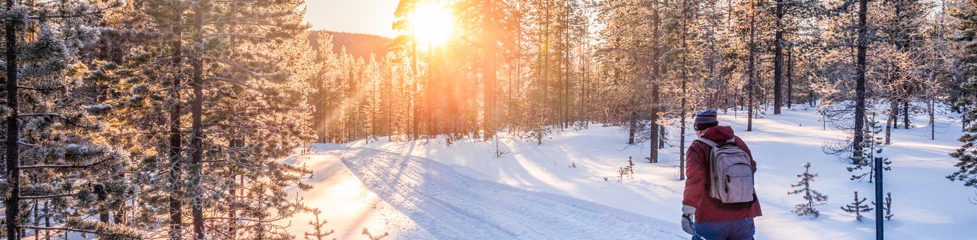 Mann auf Skiern läuft durch eine Schneelandschaft