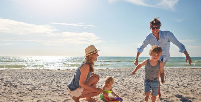 Eine Familie spielt am Strand