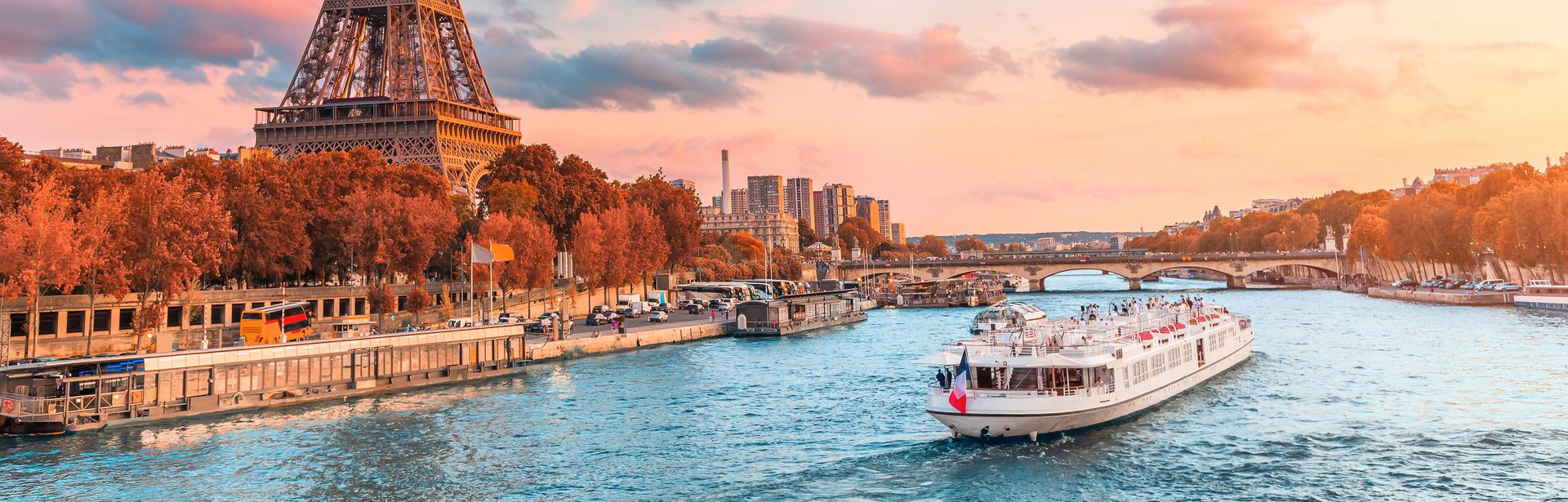 Flusskreuzfahrtschiff auf der Seine neben dem Eiffelturm in Paris