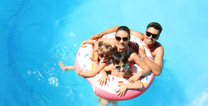 Eine Familie mit zwei Kindern und ein Schwimmreifen in einem Pool