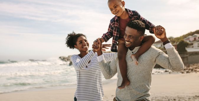 Eine Familie am Strand, Sohn sitzt auf den Schultern des Vaters