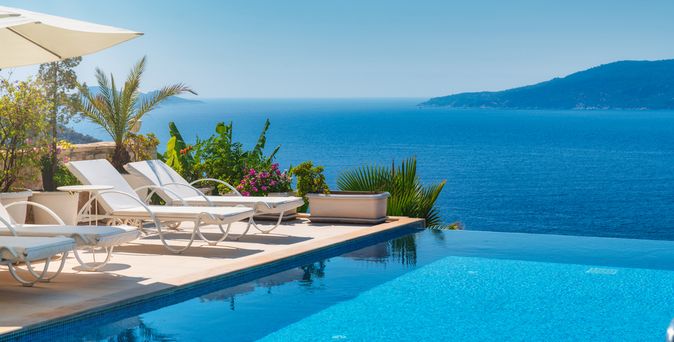 Infinity Pool mit Liegen und Blick auf das Meer