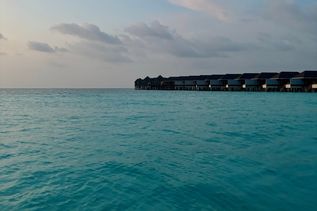 Malediven, Blick vom Wasser auf eine Reihe von Over Water Villen, Wassrbungalows