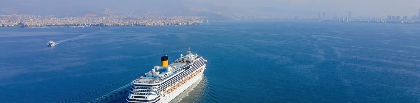 Weißes Kreuzfahrtschiff fährt bei Sonnigem Wetter über das Meer