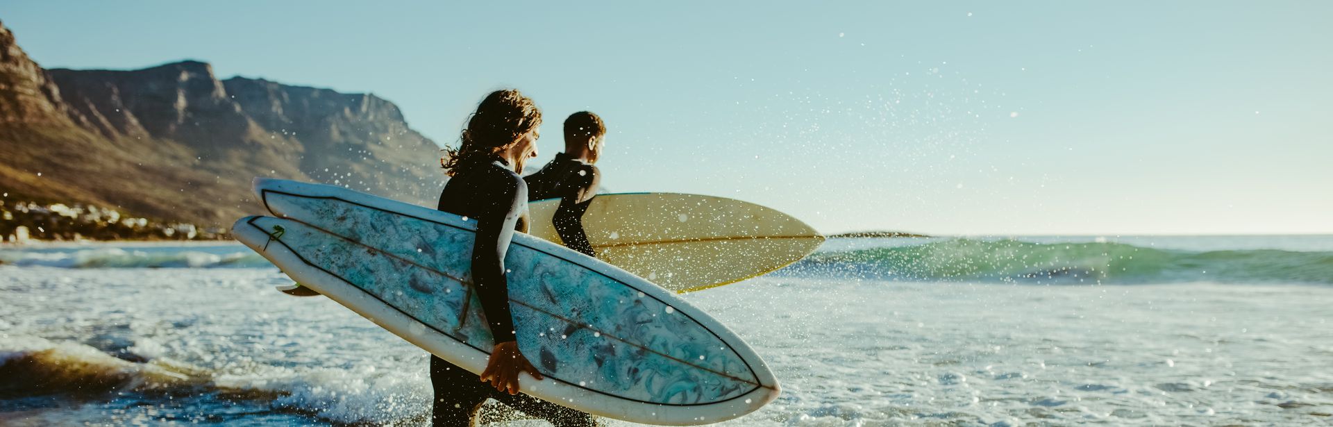 Surfer laufen auf das Meer zu