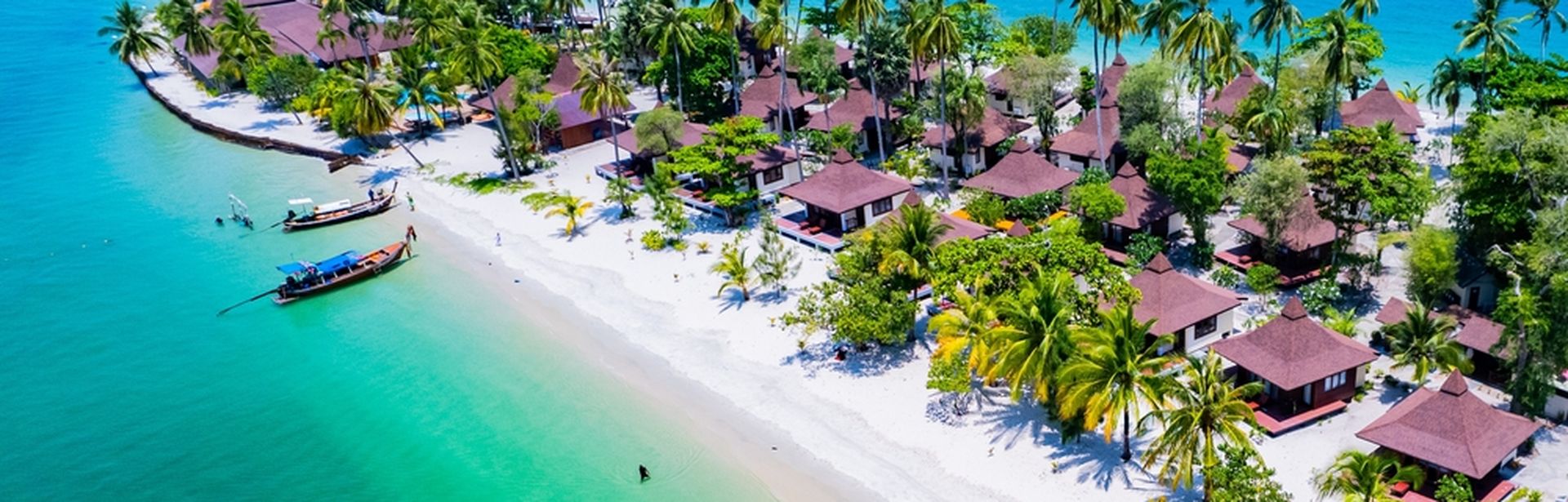 Teil einer Insel mit kleinen Häusern und Palmenstrand