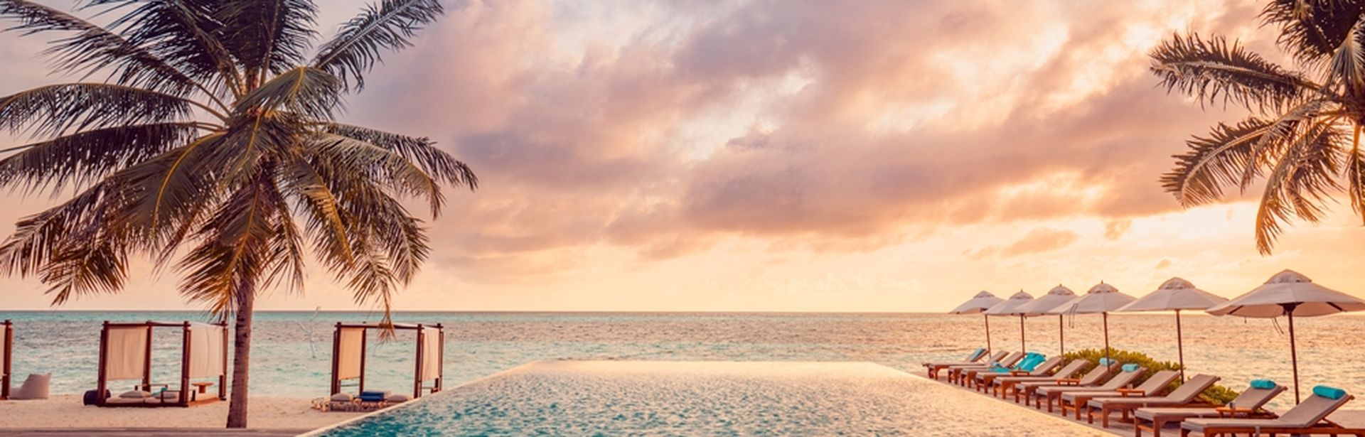 Ein Pool mit Meerblick bei Sonnenuntergang